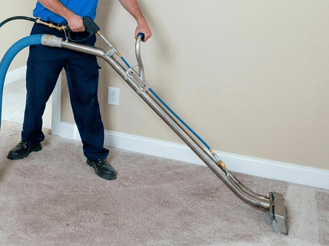 Professional operating a liquid removal machine on a carpeted floor in San Antonio, TX